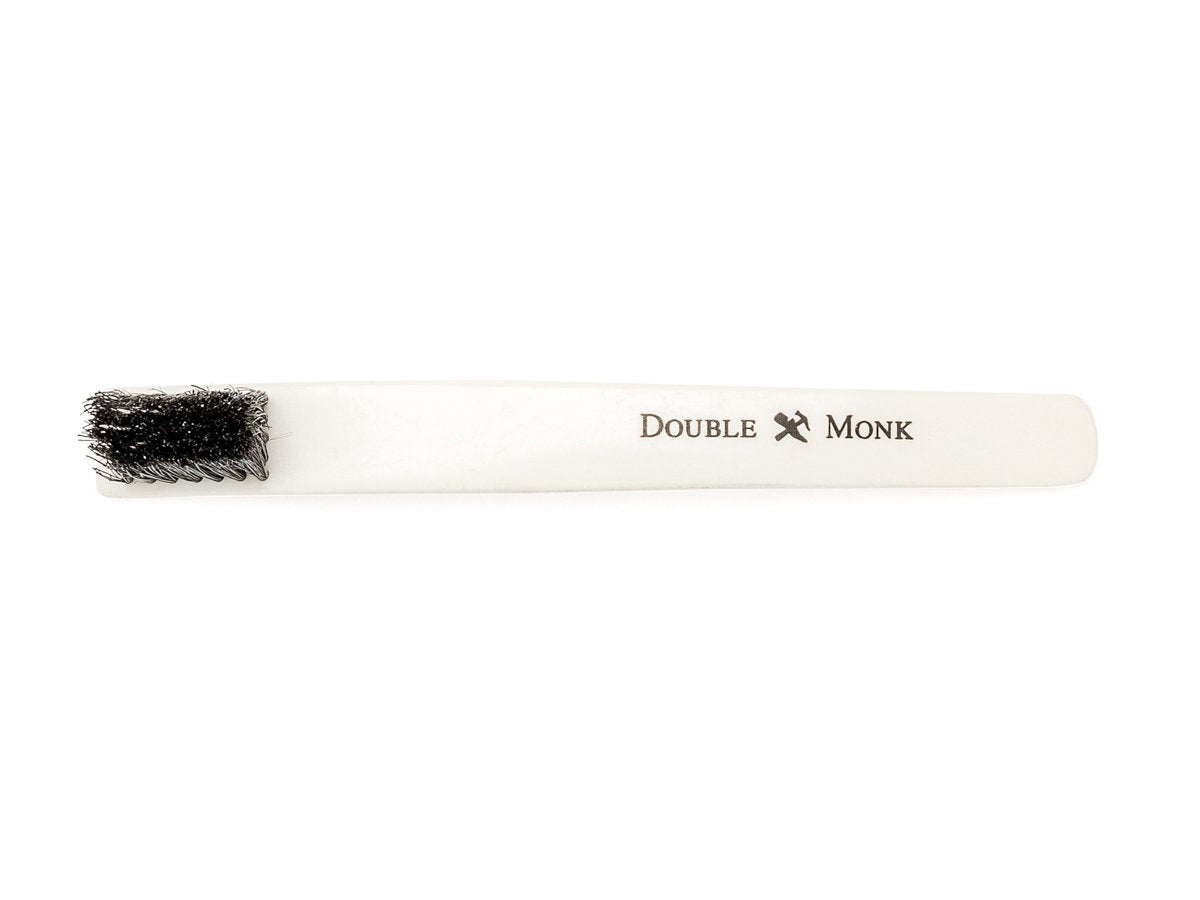 Top view of toothbrush sized bone shoe polishing brush with black bristles showing Shopovas logo