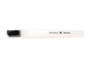 Top view of toothbrush sized bone shoe polishing brush with black bristles showing Shopovas logo