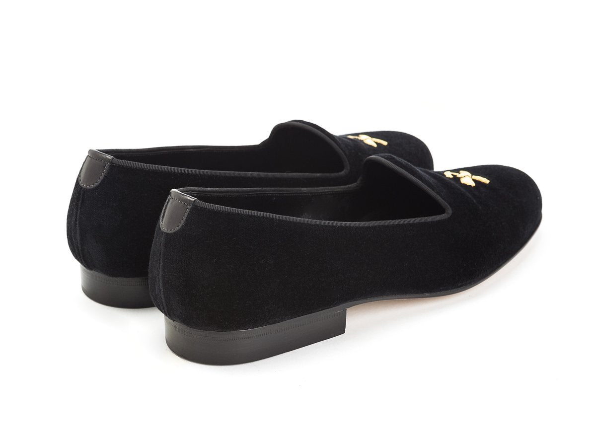 Back angle view of Edward Green Albert slippers in black velvet with hand embroidered gold Shopovas logo on toe