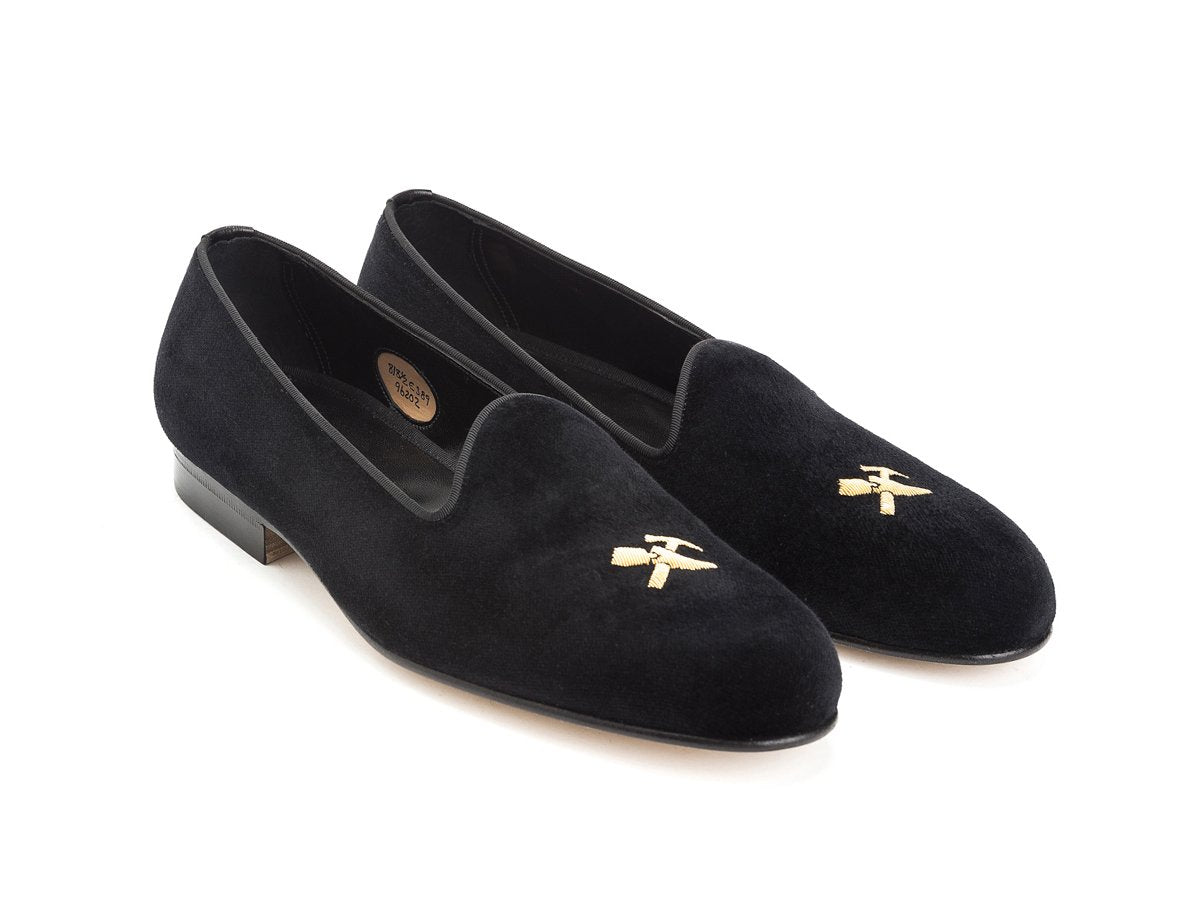 Front angle view of Edward Green Albert slippers in black velvet with hand embroidered gold Shopovas logo on toe