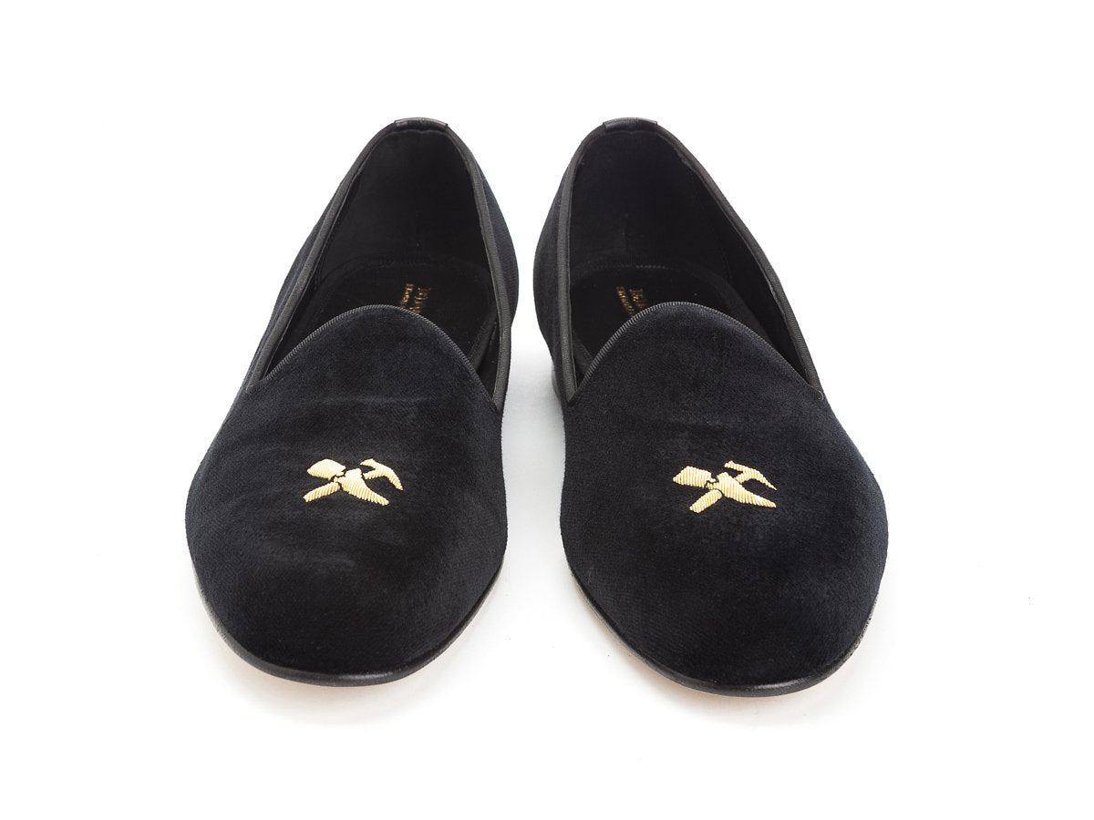 Front view of Edward Green Albert slippers in black velvet with hand embroidered gold Shopovas logo on toe