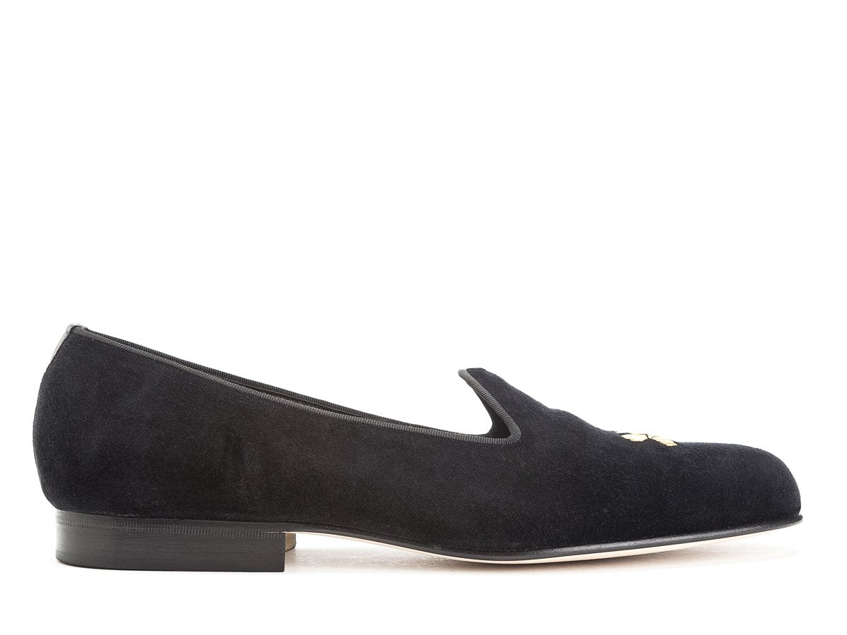 Side view of Edward Green Albert slippers in black velvet with hand embroidered gold Shopovas logo on toe