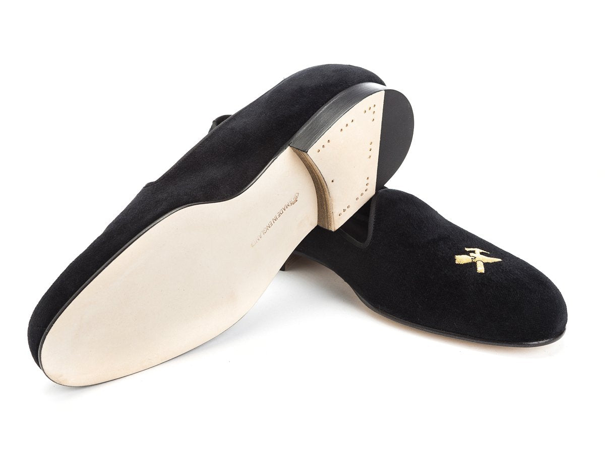 Leather sole of Edward Green Albert slippers in black velvet with hand embroidered gold Shopovas logo on toe