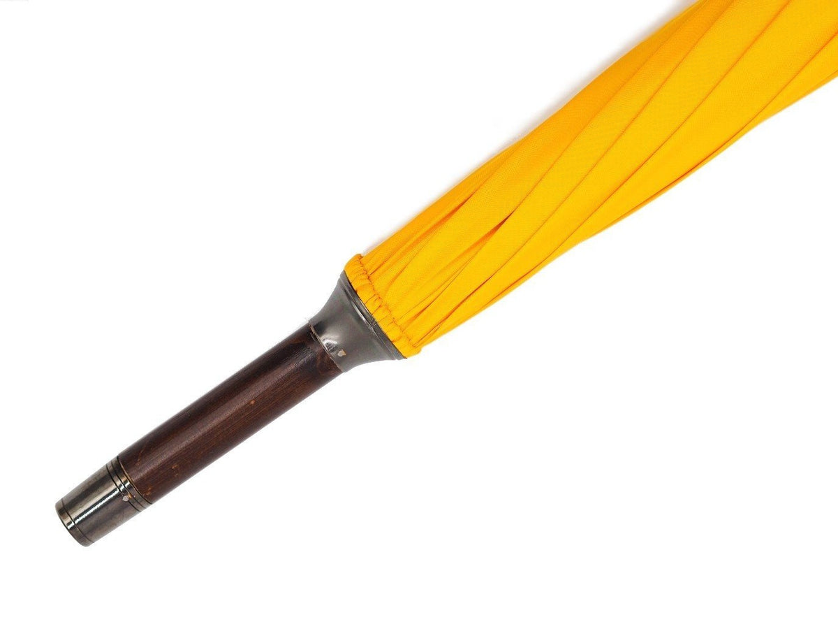 Tip end of solid bark chestnut Fox Umbrella with yellow canopy