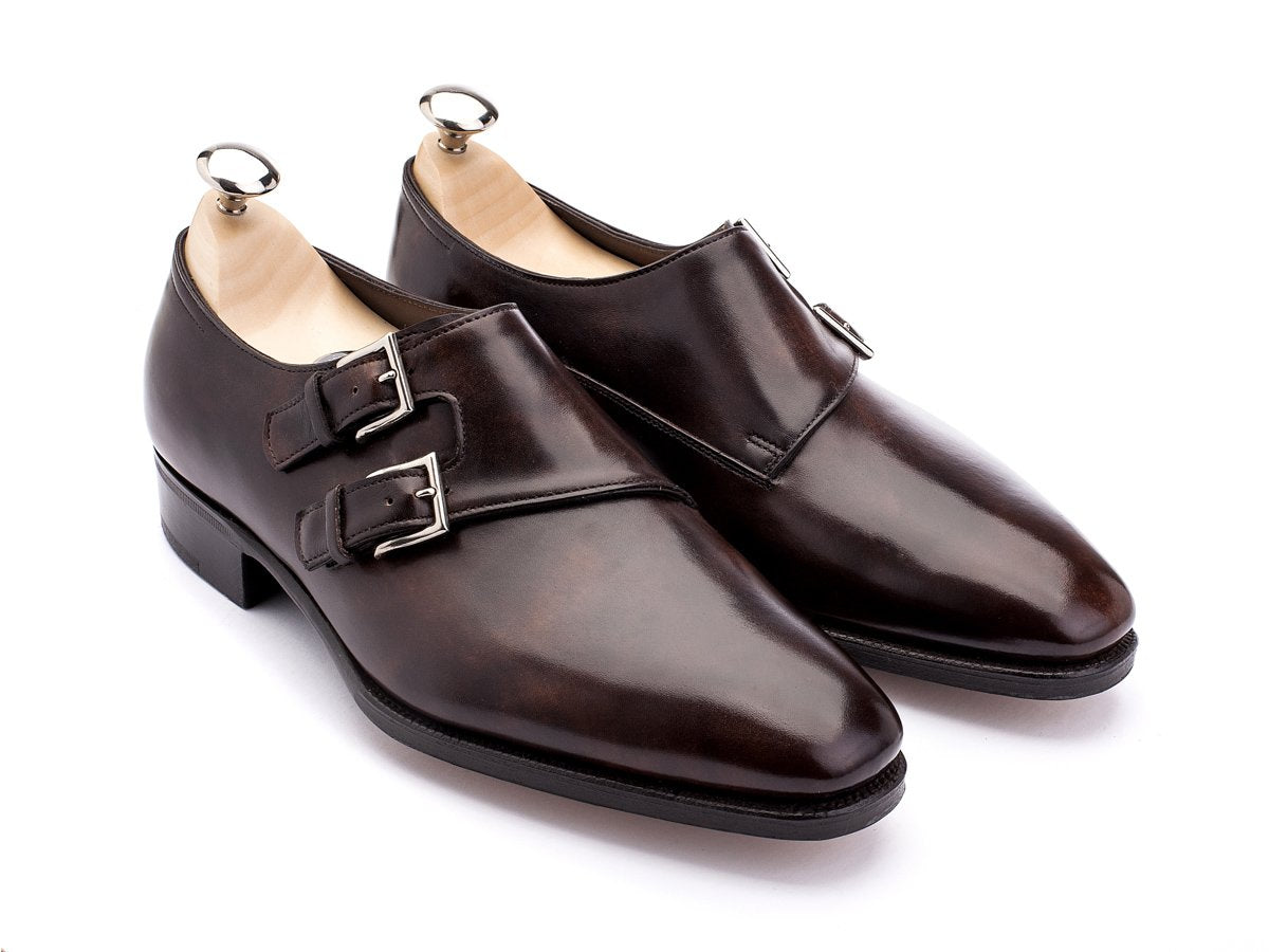 Front angle view of John Lobb Chapel plain toe swept back Shopovas strap shoes in dark brown museum calf with shoe trees